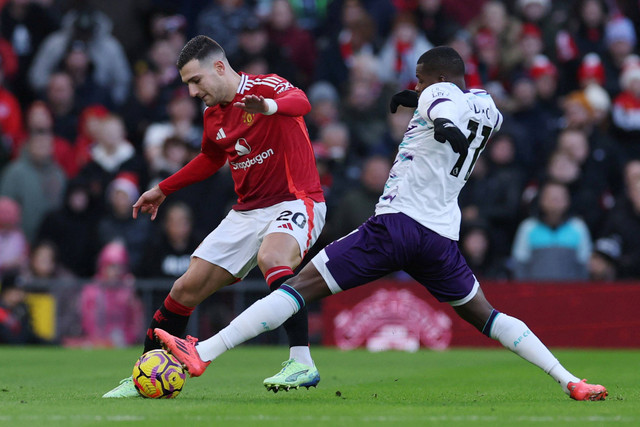 Pemain Manchester United Diogo Dalot berebut bola dengan pemain AFC Bournemouth Dango Ouattara pada pertandingan Liga Inggris di Old Trafford, Manchester, Inggris, Minggu (22/12/2024). Foto: Phil Noble/REUTERS