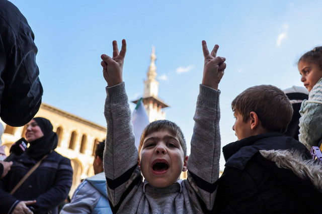 Seorang anak meluapkan kegembiraannya di pelataran Ummayad Mosque sebelum melaksanakan shalat Jum'at pertama kalinya setelah jatuhnya rezim Bashar Al-Assad. Damaskus, Syria, 13 Desember 2024. (Sumber: Reuters Photo)