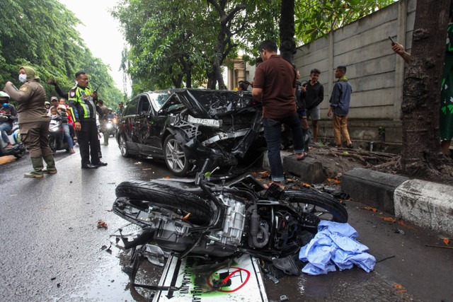 Polisi menjaga mobil yang ringsek akibat kecelakaan di Jalan Kenjeran Surabaya, Jawa Timur, Senin (23/12/2024). Foto: Didik Suhartono/ANTARA FOTO