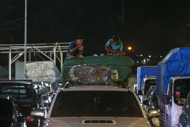 Calon penumpang menyantap makanan di atas mobilnya saat antre untuk memasuki kapal di Pelabuhan Merak, Kota Cilegon, Banten, Senin (23/12/2024). Foto: Angga Budhiyanto/ ANTARA FOTO