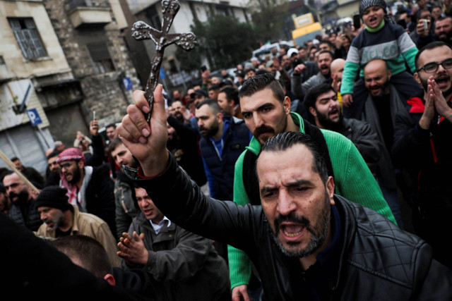 Aksi protes terhadap pembakaran pohon Natal di Hama, di lingkungan Bab Touma di Damaskus, Suriah, Selasa (24/12/2024). Foto: Amr Abdallah Dalsh/REUTERS