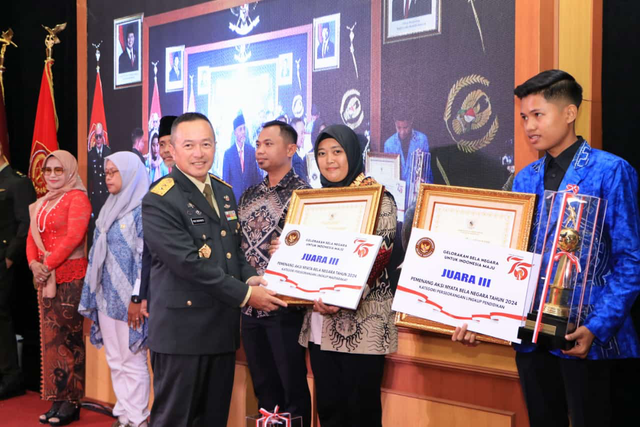 Nasabah PNM Mekaar asal Lampung Selatan, Ani Khoironi (kedua dari kanan) menerima penghargaan terbaik ketiga dalam kategori Lingkup Masyarakat pada Award Aksi Nyata Bela Negara 2024 Direktorat Jenderal Potensi Pertahanan, Kementerian Pertahanan. Foto: Dok. PNM