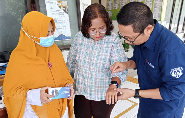 Group Head XL Axiata East Region Dodik Ariyanto (kanan), ditemani dr Ardiani Vica Dwiastuti, Penanggung Jawab PTM Puskesmas Medokan Ayu Surabaya (kiri) saat mendeteksi tekanan darah pada pasien melalui perangkat JAGATARA. Foto: Masruroh/Basra