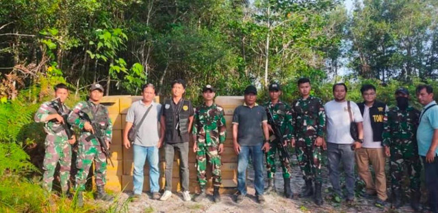 Personel TNI bersama 1.750 slop rokok ilegal asal Malaysia yang ditemukan di hutan Dusun Aruk. Foto: Dok. Instagram @beritesambas