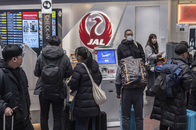 Orang-orang menunggu untuk check-in di konter Japan Airlines di aula keberangkatan Bandara Haneda di Tokyo pada tanggal 26 Desember 2024. Foto: Yuichi Yamazaki/AFP 