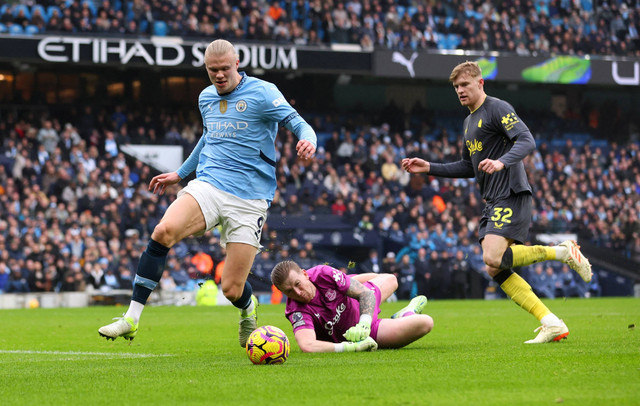 Pemain Manchester City Erling Haaland berusaha melewati penjaga gawang Everton Jordan Pickford pada pertandingan Liga Inggris di Etihad Stadium, Manchester, Inggris, Kamis (26/12/2024). Foto: Craig Brough/REUTERS