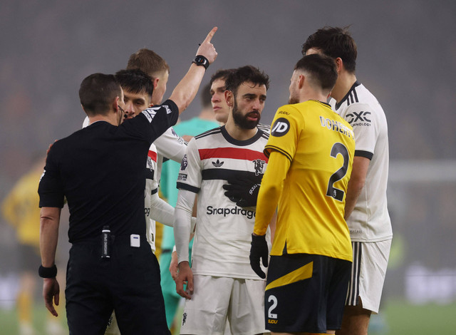 Wasit Tony Harrington memberi kartu merah pada Bruno Fernandes dalam laga Wolves vs Manchester United di Stadion Molineux dalam lanjutan Liga Inggris 2024/25, Jumat (27/12) dini hari WIB. Foto: Action Images via Reuters/Matthew Childs