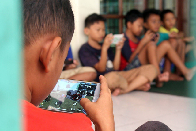 generasi muda yang sedang asik bermain game online bersama temannya https://florestimurkab.go.id/diskotikflotim/bahaya-penggunaan-gadget-bagi-anak/