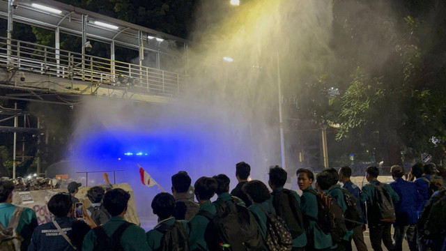 Water canon mulai ditembakan ke massa aksi tolak PPN 12% di Jakarta, Jumat (27/12). Foto: Abid Raihan/kumparan