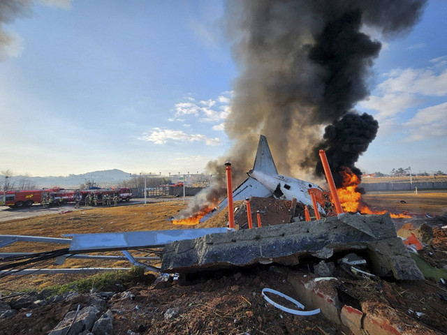 Petugas pemadam kebakaran melakukan operasi pemadaman di sebuah pesawat yang melaju kabur di Bandara Internasional Muan di Muan, Provinsi Jeolla Selatan, Korea Selatan, Minggu (29/12/2024). Foto: Yonhap via REUTERS