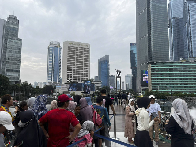 Antrean panjang untuk berfoto dengan monumen selamat datang di Halte Bundera HI, Minggu (29/12/2024). Foto: Rayyan Farhansyah/kumparan