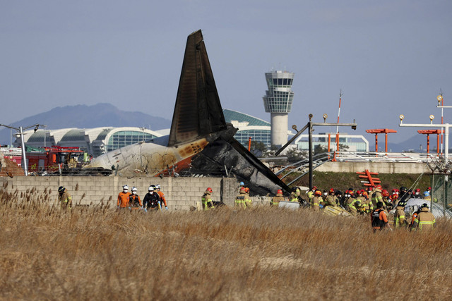 Petugas pemadam kebakaran melakukan operasi penyelamatan di sebuah pesawat yang keluar dari landasan pacu di Bandara Internasional Muan di Muan, Provinsi Jeolla Selatan, Korea Selatan, Minggu (29/12/2024). Foto: Yonhap via REUTERS