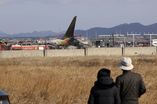 Petugas pemadam kebakaran melakukan operasi penyelamatan di sebuah pesawat yang keluar dari landasan pacu di Bandara Internasional Muan di Muan, Provinsi Jeolla Selatan, Korea Selatan, Minggu (29/12/2024). Foto: Yonhap via REUTERS