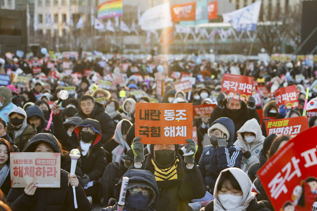 Para pengunjuk rasa menghadiri aksi unjuk rasa menentang Presiden Korea Selatan yang dimakzulkan, Yoon Suk Yeol, yang mendeklarasikan darurat militer, yang dibatalkan beberapa jam kemudian, di Seoul, Korea Selatan, Sabtu (28/12/2024). Foto: Kim Soo-Hyeon/REUTERS