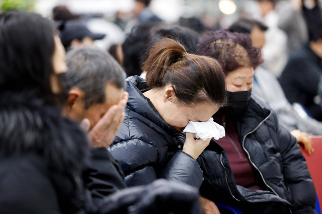 Keluarga penumpang Jeju Air yang mengalami kecelakaan menangis di Bandara Internasional Muan, Provinsi Jeolla, Korea Selatan, Minggu (29/12/2024). Foto: Kim Hong-Ji/REUTERS