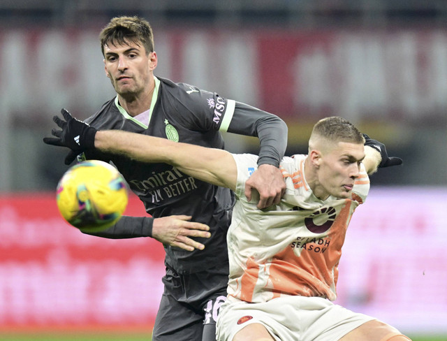 Matteo Gabbia dari AC Milan beraksi dengan pemain AS Roma Artem Dovbyk pada pertandingan Liga Italia antara AC Milan vs AS Roma di San Siro, Milan, Italia, Senin (30/12/2024) dini hari WIB. Foto: Daniele Mascolo/REUTERS