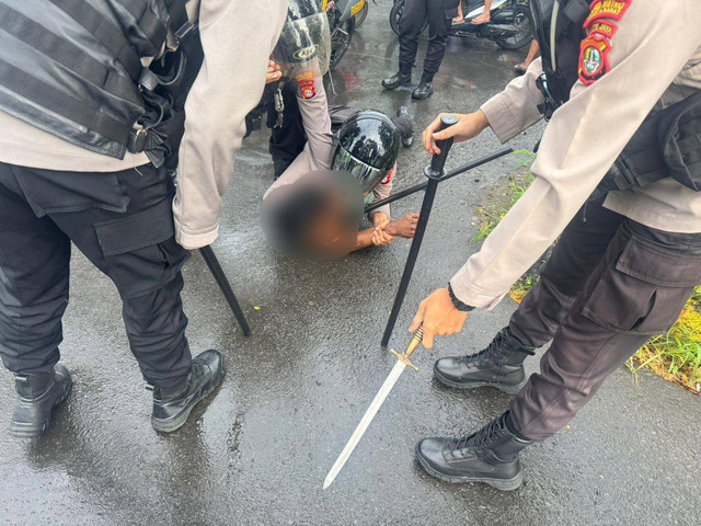 Polisi saat menangkap pria yang menyetop bus dan melawan polisi sambil membawa samurai di Daan Mogot, Jakarta Barat. Foto: Dok. Istimewa