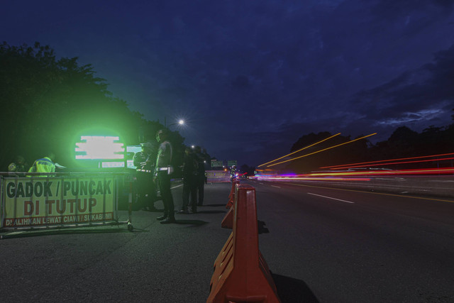 Petugas kepolisian melakukan penutupan jalur di pintu keluar tol Gadog, Ciawi, Kabupaten Bogor, Jawa Barat, Selasa (31/12/2024).  Foto: Yulius Satria Wijaya/ANTARA FOTO