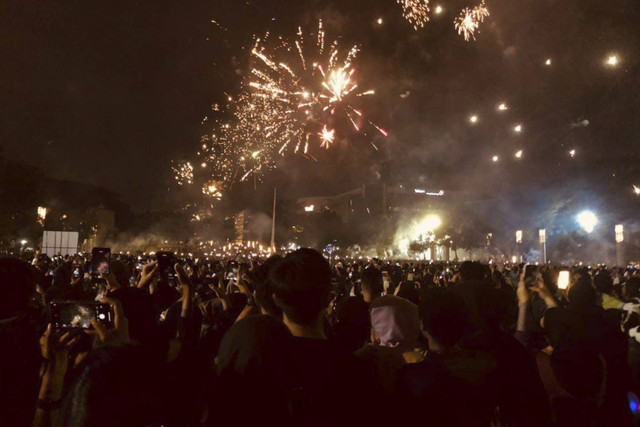 Sejumlah warga menyaksikan pesta kembang api saat malam perayaan tahun baru 2025 di lapangan Gasibu, Bandung, Rabu (1/1/2025).  Foto: Robby Bouceu/kumparan