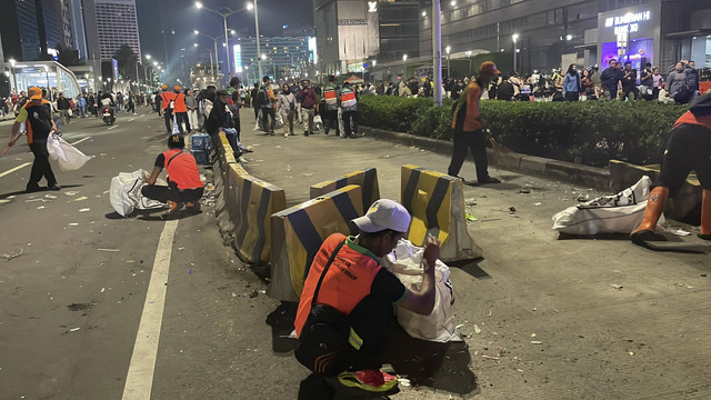 Pasukan oranye mulai membersihkan sampah yang berserakan usai perayaan Tahun Baru 2025, di kawasan Bundaran HI, Jakarta Pusat, Rabu (1/1/2025). Foto: Fadhil Pramudya/kumparan