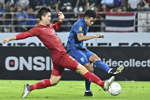 Pemain Vietnam Do Duy Manh (kiri) mencoba menjegal pemain Thailand Bordin Phala saat pertandingan sepak bola final Piala AFF leg kedua antara Vietnam dan Thailand di Stadion Thammasat, Bangkok (16/1/2023). Foto: Lillian Suwanrumpha/AFP