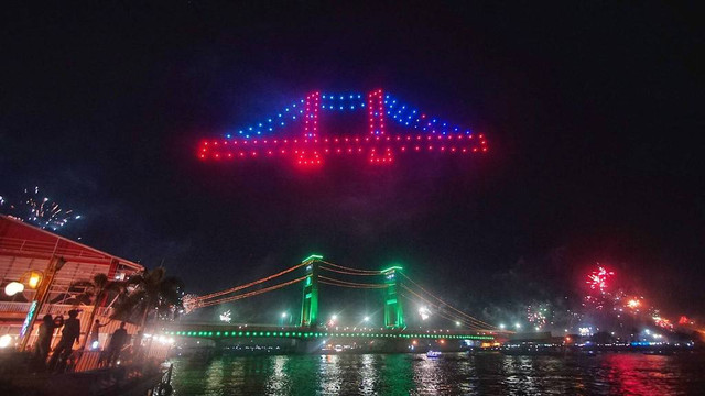 Aksi ratusan drone membentuk visual Jembatan Ampera di atas sungai musi saat perayaan pergantian tahun baru 2025 di Palembang, Rabu (1/1) Foto: ary priyanto/urban id