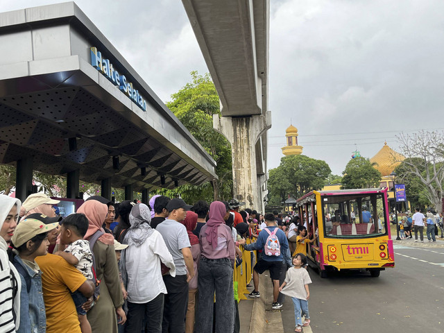 Pengunjung Taman Mini Indonesia Indah (TMII) terlihat mengantri angkutan keliling (angling) di tengah cuaca mendung, Jakarta Timur, Rabu (1/1/2025). Foto: Alya Zahra/kumparan 