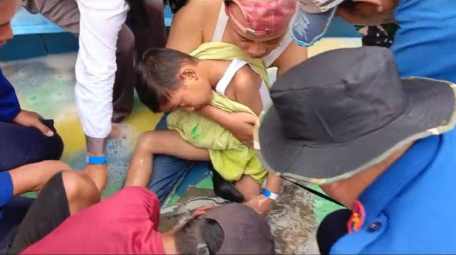 Damkarmat Lampung Selatan saat evakuasi kaki anak yang masuk saluran air kolam. | Foto: Istimewa