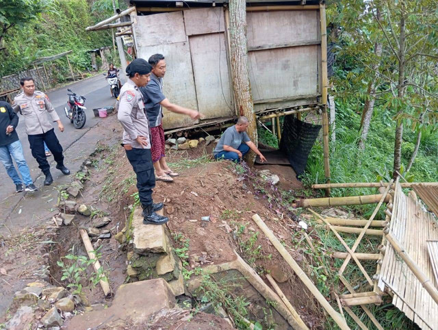 Petugas memeriksa lokasi kejadian 9 orang terperosok ke jurang saat berteduh di bekas bangunan warung di Dusun Badut, Desa Jugo, Kecamatan Mojo, Kabupaten Kediri yang menewaskan 1 orang. Foto: Dok. Istimewa