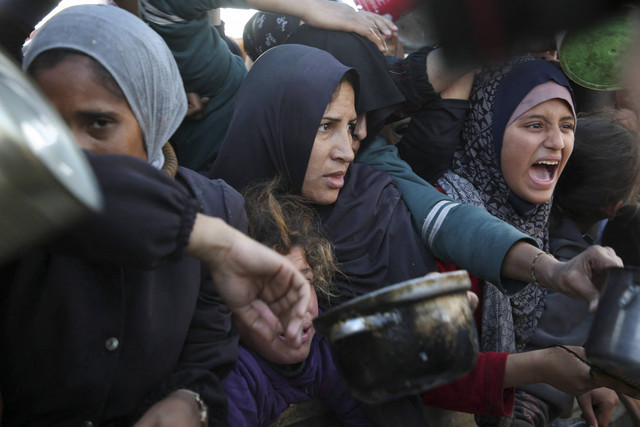 Warga Palestina berkumpul untuk menerima makanan di tengah krisis kelaparan akibat konflik Israel-Hamas, di Khan Younis, Jalur Gaza selatan, Kamis (2/1/2025). Foto: Hatem Khaled/REUTERS