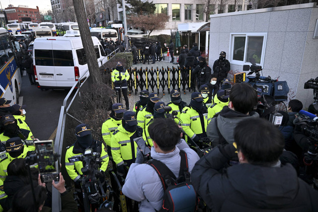 Polisi dan penyelidik anti-korupsi tiba di kediaman Presiden Korea Selatan yang dimakzulkan Yoon Suk Yeol di Seoul, Korea Selatan, Jumat (3/1/2025). Foto: Jung Yeon-je/AFP