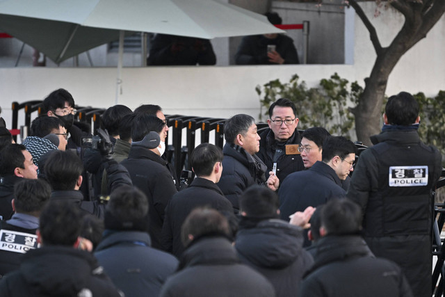 Polisi dan penyelidik anti-korupsi tiba di kediaman Presiden Korea Selatan yang dimakzulkan Yoon Suk Yeol di Seoul, Korea Selatan, Jumat (3/1/2025). Foto: Jung Yeon-je/AFP