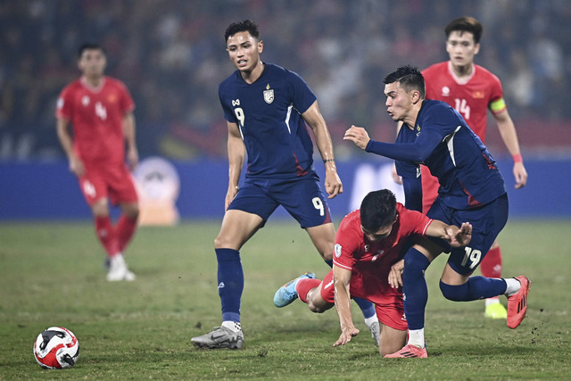 Pemain Thailand William Weidersjo menjatuhkan pemain Vietnam Patrik Gustavsson  saat final leg pertama Piala AFF 2024 di Viet Tri Stadium, Vietnam, Kamis (2/1/2025). Foto: Nhac NGUYEN/AFP