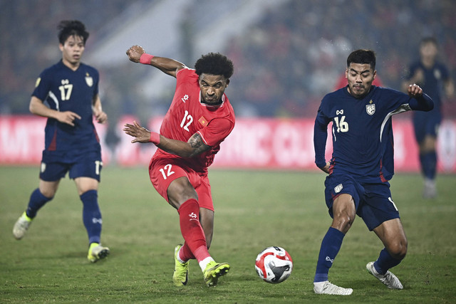 Pemain Vietnam Rafaelson menendang bola yang coba dihalau pemain Thailand Akarapong Pumwisat saat final leg pertama Piala AFF 2024 di Viet Tri Stadium, Vietnam, Kamis (2/1/2025). Foto: Nhac NGUYEN/AFP