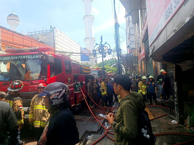 Petugas pemadam tangani kebakaran di sebuah gang samping Kings Shopping Center, Jalan Dalem Kaum, Kecamatan Regol, Kota Bandung, pada Jumat (3/1). Dok. Robby Bouceu/kumparan