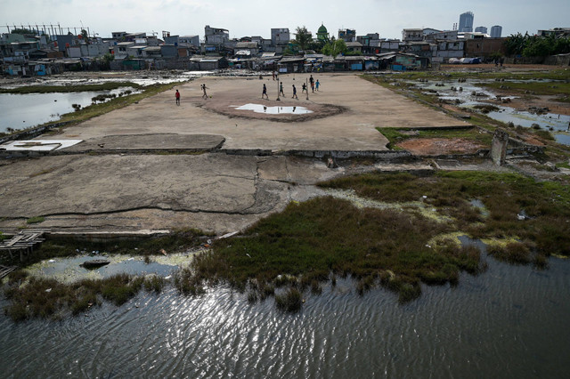 Sejumlah anak bermain di dekat genangan air laut di permukiman pesisir kawasan Muara Baru, Jakarta, Jumat (3/1/2025). Foto: ANTARA FOTO/Fauzan