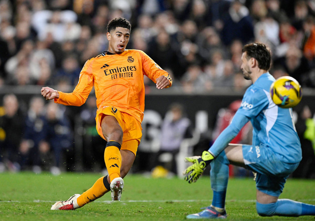 Jude Bellingham bobol gawang Stole Dimitrievski saat Valencia vs Real Madrid dalam laga Liga Spanyol 2024/25 di Stadion Mestalla pada Sabtu (4/1) dini hari WIB. Foto: REUTERS/Pablo Morano