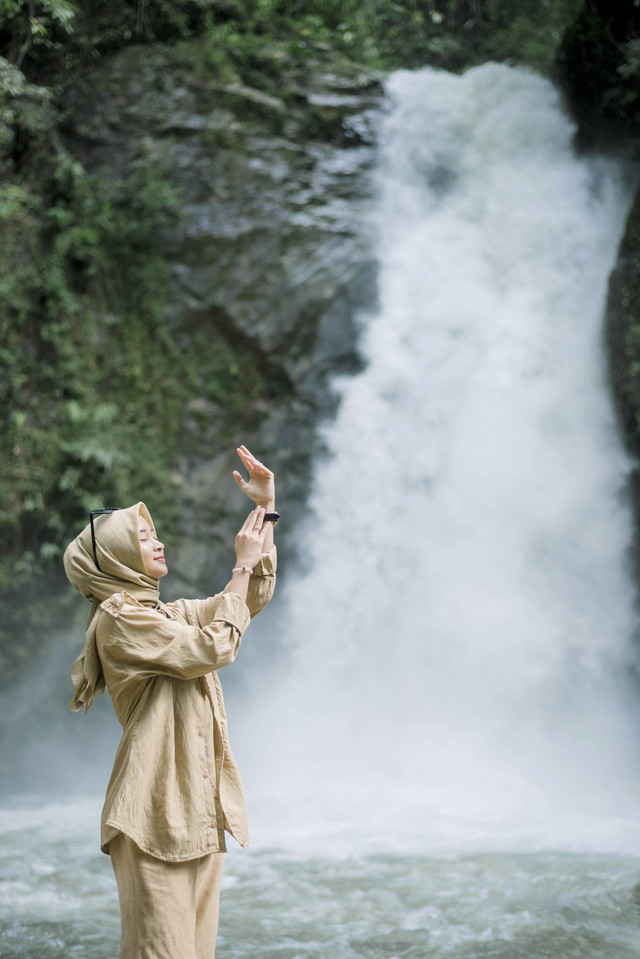 Wisatawan yang berwisata di air terjun. Foto: Shutterstock