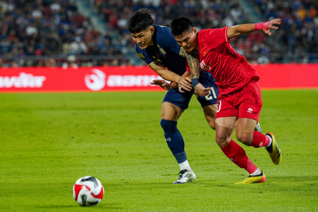 Pemain Timnas Thailand Suphanan Bureerat berebut bola dengan pemain Timnas Vietnam Tuan Hai Pham pada pertandingan leg kedua final Piala AFF 2024 di Stadion Nasional Rajamangala, Bangkok, Thailand, Minggu (5/1/2025). Foto: CHANAKARN LAOSARAKHAM/AFP