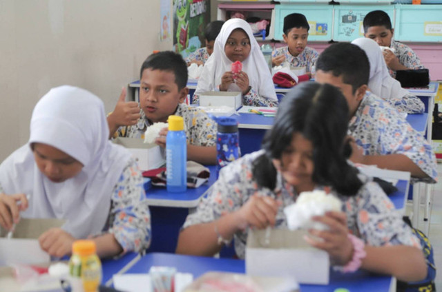 Sejumlah siswa menyantap makanan saat simulasi program Makan Siang Bergizi Gratis di sekolah wilayah Lanud Halim Perdanakusuma di SDS Angkasa 5 Lanud Halim Perdanakusuma, Jakarta, Selasa (26/11/2024). Foto: Iqbal Firdaus/kumparan