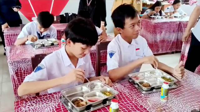 Para siswa menikmati makan bergizi gratis yang merupakan program dari Presiden Prabowo Subianto. (foto: febry kodongan)