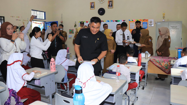 Sekretaris Daerah Kota Palembang, Aprizal Hasyim saat membagikan Makan Bergizi Gratis di SDN 25. Foto : Diskominfo Palembang