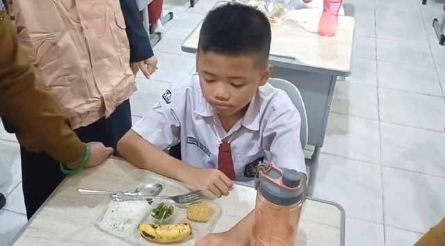 Seorang siswa SDN 25 Palembang Gibran saat mencoba menu Makanan Bergizi Gratis. Foto : Abdullah Toriq/Urban Id