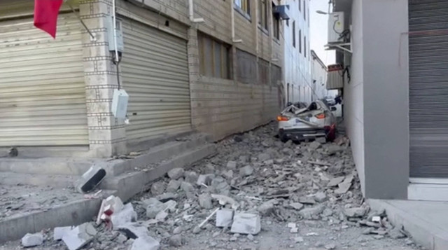 Sebuah mobil yang rusak berada di antara reruntuhan di jalan setelah gempa bumi di Kabupaten Lhatse, Kota Shigatse, Daerah Otonomi Tibet, China, Selasa (7/1/2025). Foto: Social Media via REUTERS 