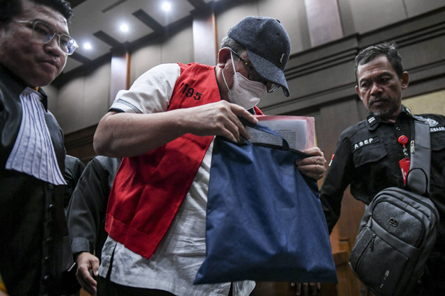 Mangapul (tengah) terdakwa suap dan gratifikasi pengurusan perkara Gregorius Ronald Tannur, mengenakan rompi tahanan saat jeda sidang di Pengadilan Tipikor, Jakarta, Selasa (7/1/2025). Foto: Hafidz Mubarak A/ANTARA FOTO