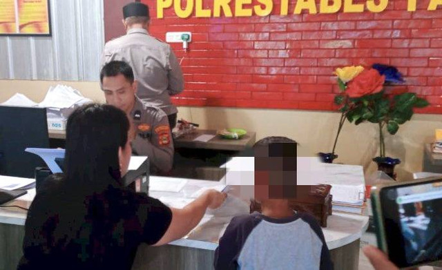 Rusmiati bersama anaknya saat membuat laporan polisi. (ist)