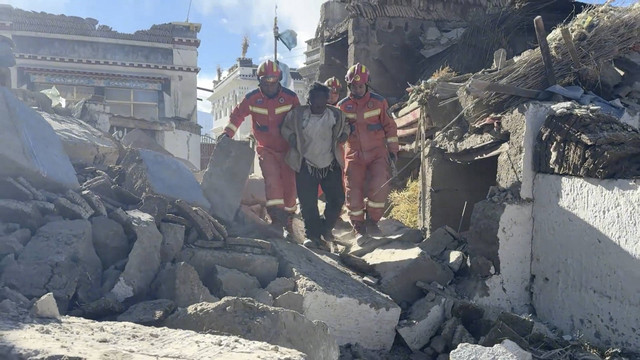 Anggota tim penyelamat membantu seorang korban berjalan di antara reruntuhan setelah gempa bumi di lokasi yang disebut sebagai Kota Shigatse, Daerah Otonomi Tibet, China, Selasa (8/1/2025). Foto: Tibet Fire and Rescue via REUTERS