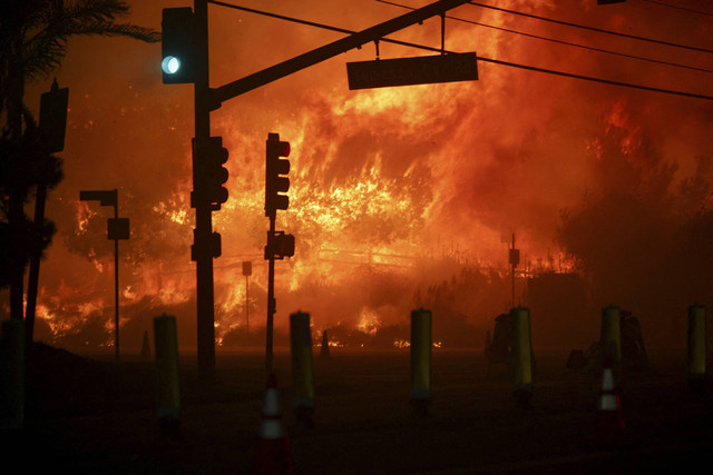 Lampu sinyal menyala hijau di Pacific Coast Highway saat kebakaran hutan terjadi di lingkungan Pacific Palisades, Los Angeles barat, California, Selasa (7/1/2025). Foto: Daniel Cole/REUTERS 