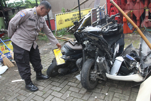 Polisi melihat bangkai kendaraan roda dua yang ringsek usai terlibat kecelakaan beruntun di Kota Batu, Jawa Timur, Kamis (9/1/2025). Foto: ANTARA FOTO/Ari Bowo Sucipto