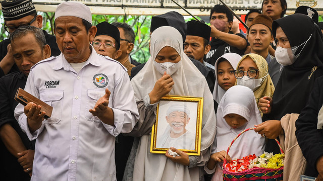 Istri pelawak sekaligus politikus Nurul Qomar, Siti Maryam (tengah) membawa bingkai foto dan berdoa saat pemakaman di TPU Carang Pulang, Pagedangan, Kabupaten Tangerang, Banten, Kamis (9/1/2025). Foto: ANTARA FOTO/Sulthony Hasanuddin